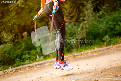 Image of Close up of woman feet jumping in skipping rope