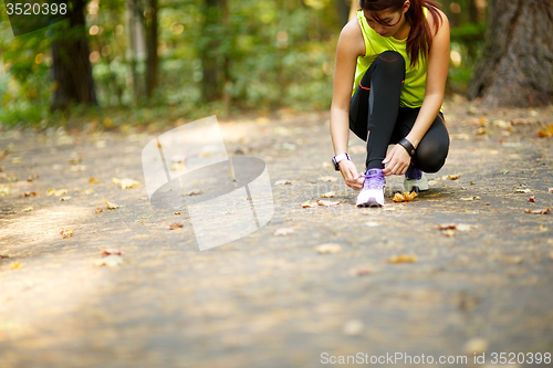 Image of woman runner tying shoelaces