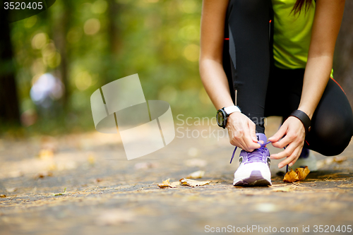 Image of woman runner tying shoelaces