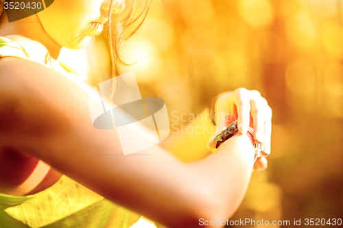 Image of Close up image of young woman checking time