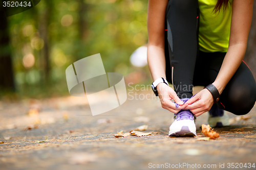 Image of woman runner tying shoelaces