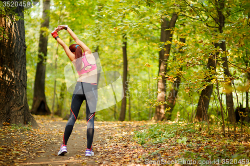 Image of woman runner stretching before her workout