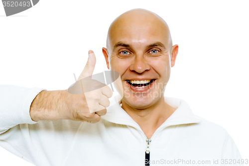 Image of Bald smiling blue-eyed man with thumb up. Studio. isolated
