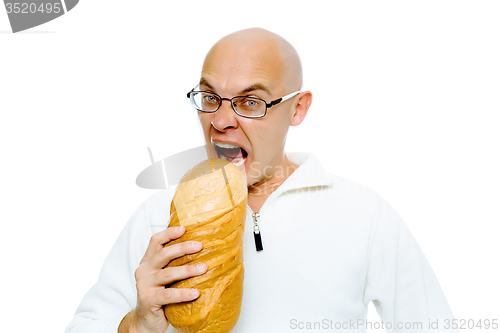 Image of Hungry bald man bites a a large loaf. Studio. isolated