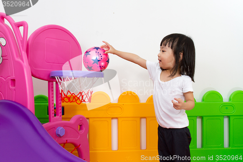 Image of Asian Chinese little girl playing basketball