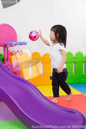 Image of Asian Chinese little girl playing basketball