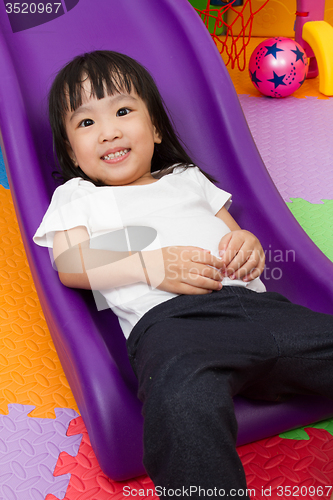 Image of Asian Chinese little girl playing on the slide