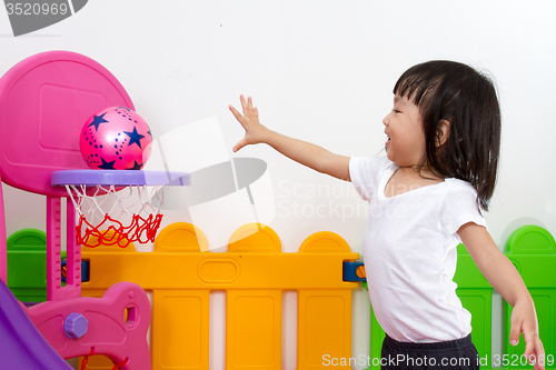 Image of Asian Chinese little girl playing basketball