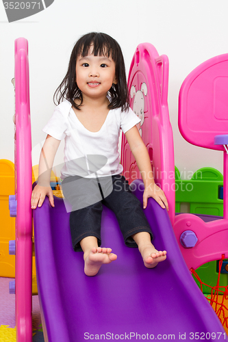 Image of Asian Chinese little girl playing on the slide