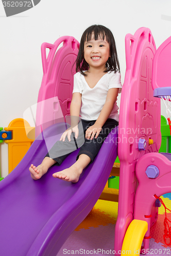 Image of Asian Chinese little girl playing on the slide