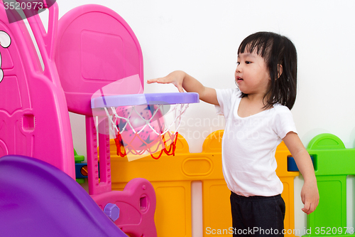 Image of Asian Chinese little girl playing basketball