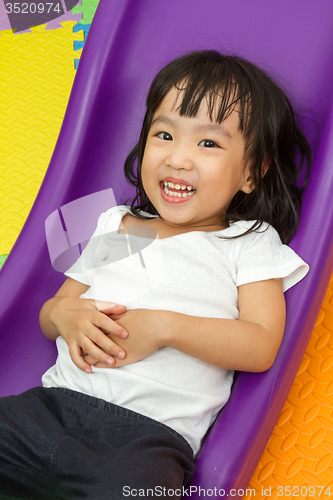 Image of Asian Chinese little girl playing on the slide