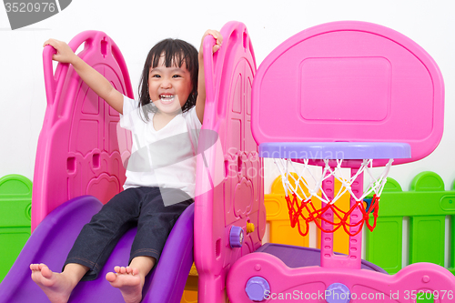 Image of Asian Chinese little girl playing on the slide