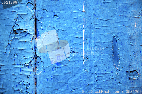 Image of dirty stripped  in the blue wood door and rusty nail