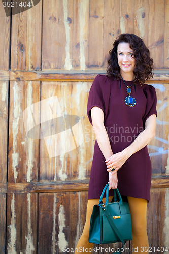 Image of beautiful middle-aged woman in burgundy dress