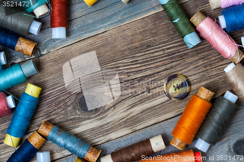 Image of one vintage button and coils of different threads