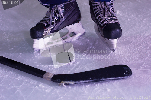 Image of hockey sticsk and puck on ice