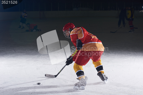 Image of teen ice hockey player in action