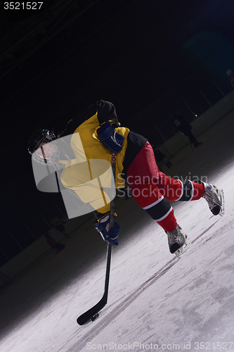 Image of teen ice hockey player in action