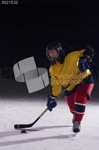 Image of teen ice hockey player in action