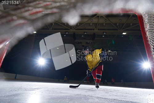 Image of teen ice hockey player in action