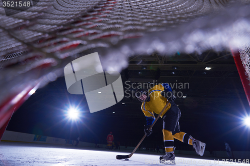 Image of teen ice hockey player in action