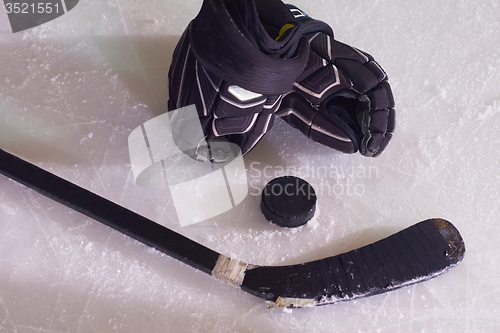 Image of hockey sticsk and puck on ice