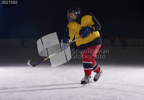 Image of teen ice hockey player in action