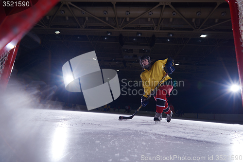 Image of teen ice hockey player in action