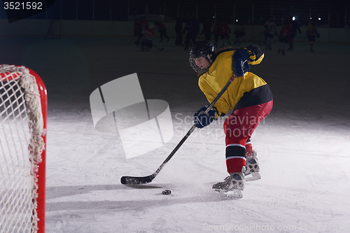 Image of teen ice hockey player in action