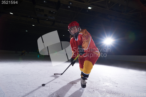 Image of teen ice hockey player in action