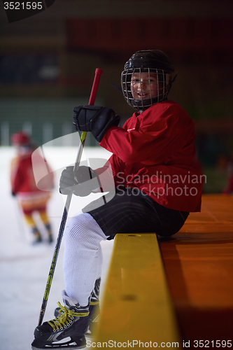 Image of children ice hockey players on bench