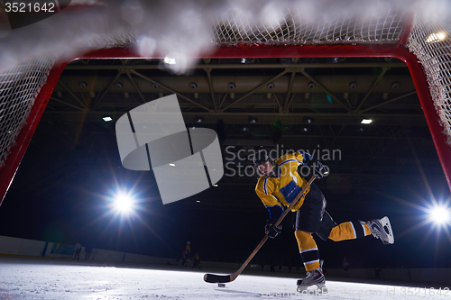 Image of teen ice hockey player in action