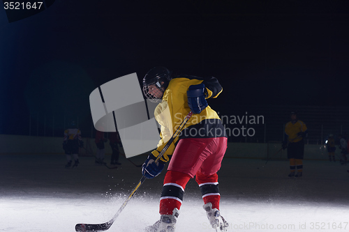 Image of teen ice hockey player in action