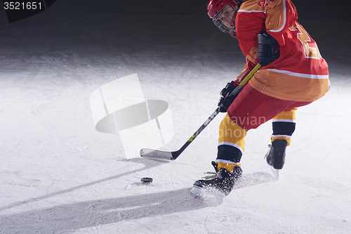 Image of teen ice hockey player in action