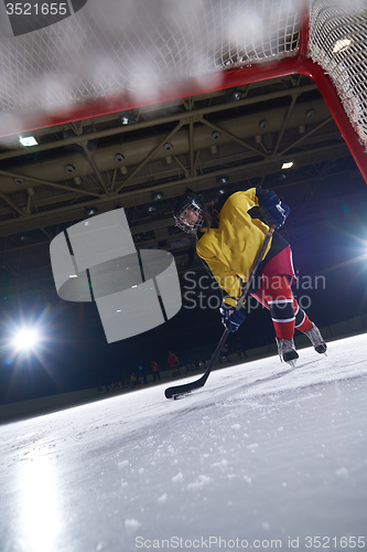 Image of teen ice hockey player in action