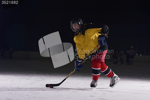 Image of teen ice hockey player in action