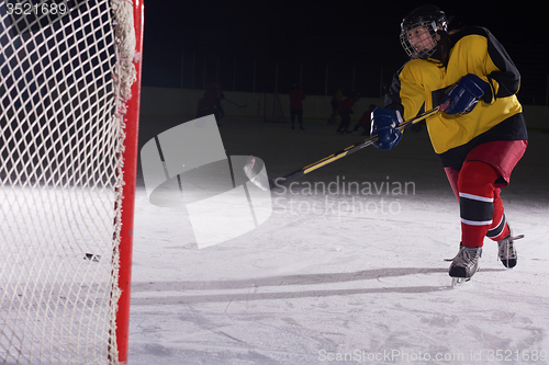 Image of teen ice hockey player in action