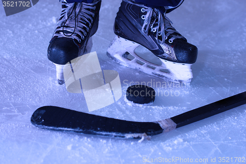 Image of hockey sticsk and puck on ice