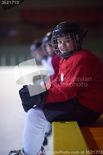 Image of children ice hockey players on bench