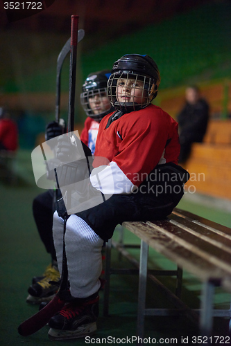 Image of children ice hockey players on bench