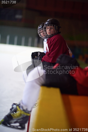 Image of children ice hockey players on bench