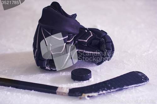 Image of hockey sticsk and puck on ice