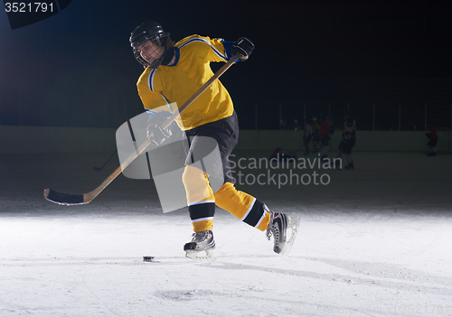 Image of teen ice hockey player in action