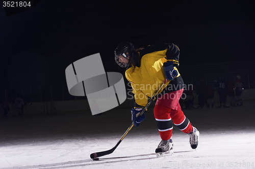 Image of teen ice hockey player in action