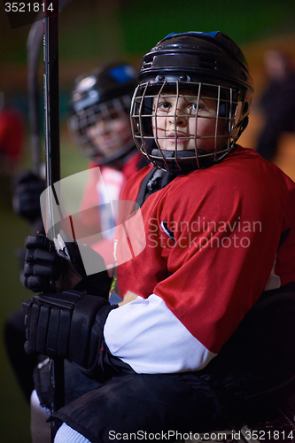 Image of children ice hockey players on bench