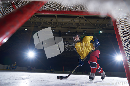 Image of teen ice hockey player in action