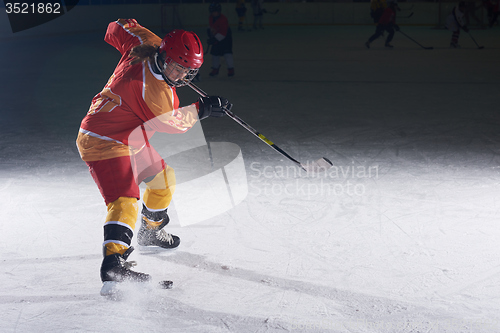 Image of teen ice hockey player in action