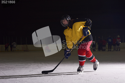 Image of teen ice hockey player in action