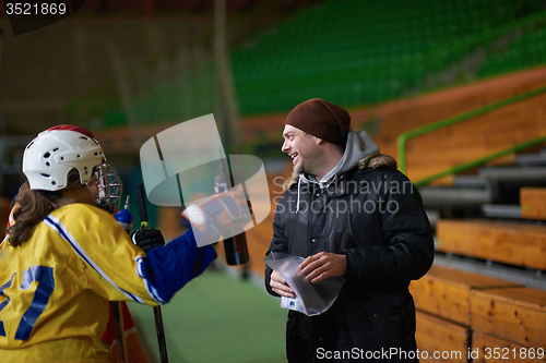 Image of teen ice hockey players team meeting with trainer